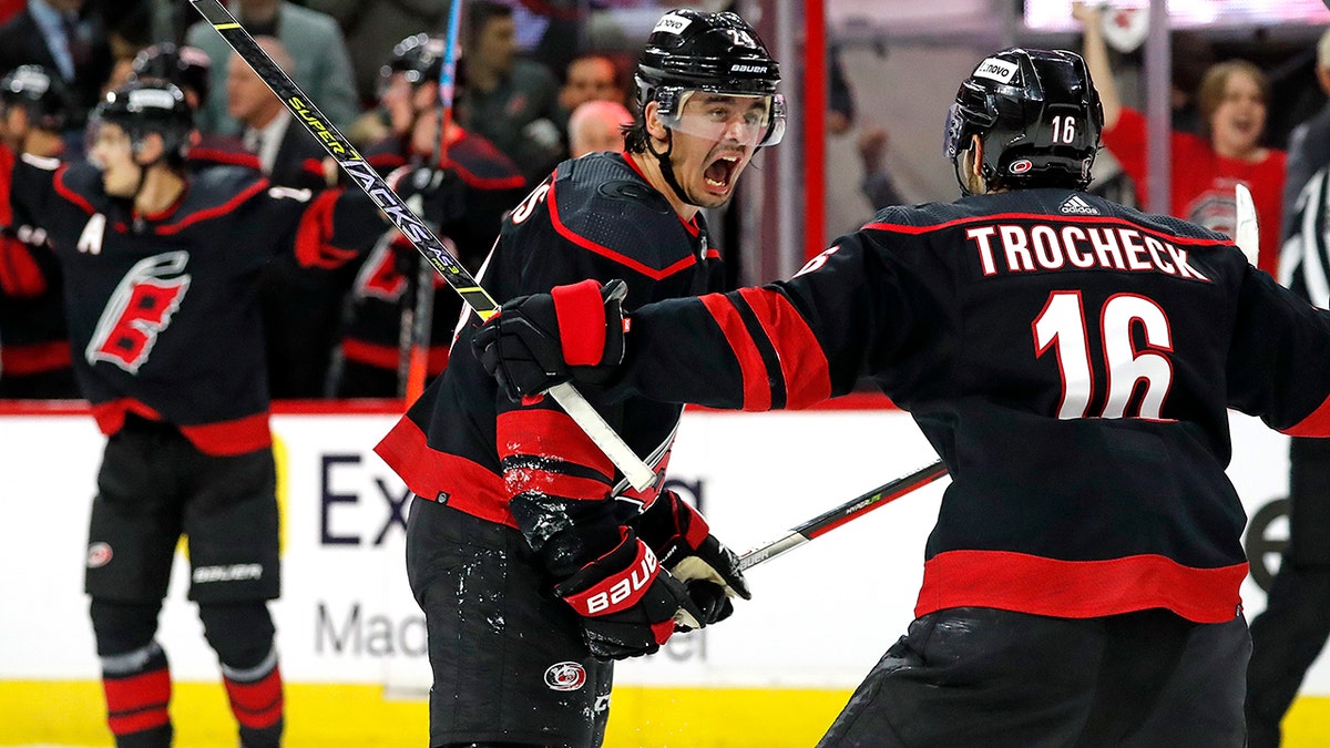 Carolina Hurricanes' Seth Jarvis, center, celebrates his goal with teammate Vincent Trocheck (16) during the second period of Game 5 of an NHL hockey Stanley Cup first-round playoff series against the Boston Bruins in Raleigh, N.C., Tuesday, May 10, 2022. 
