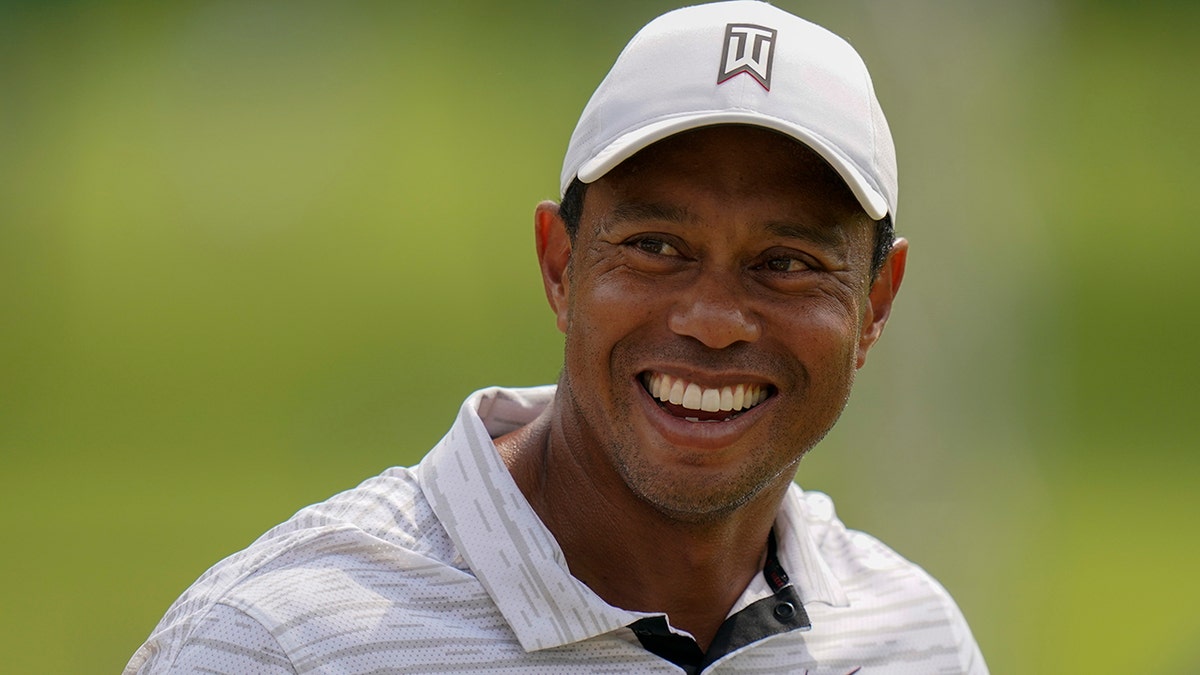 Tiger Woods smiles on the driving range before a practice round for the PGA Championship golf tournament, Tuesday, May 17, 2022, in Tulsa, Okla.