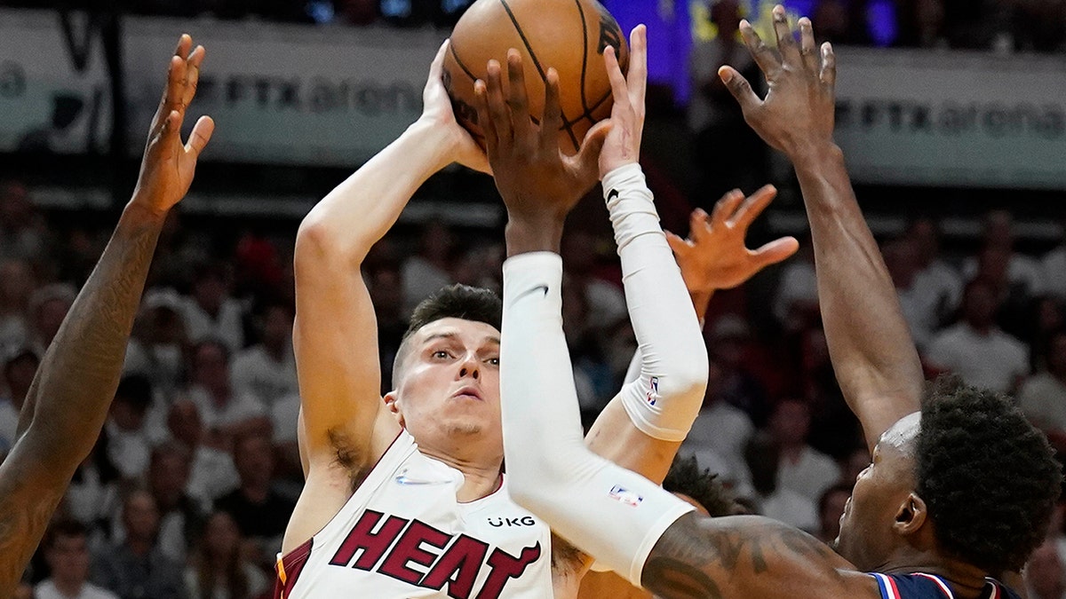 Miami Heat guard Tyler Herro (14) drives to the basket over Philadelphia 76ers forward Paul Reed (44) and guard Matisse Thybulle (22) during the second half of Game 1 of an NBA basketball second-round playoff series, Monday, May 2, 2022, in Miami.