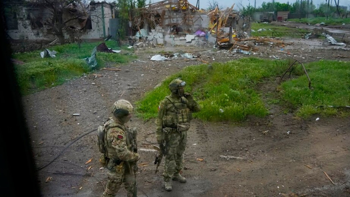 Russians walk along the road toward the besieged Azovstal steel plant in Mariupol