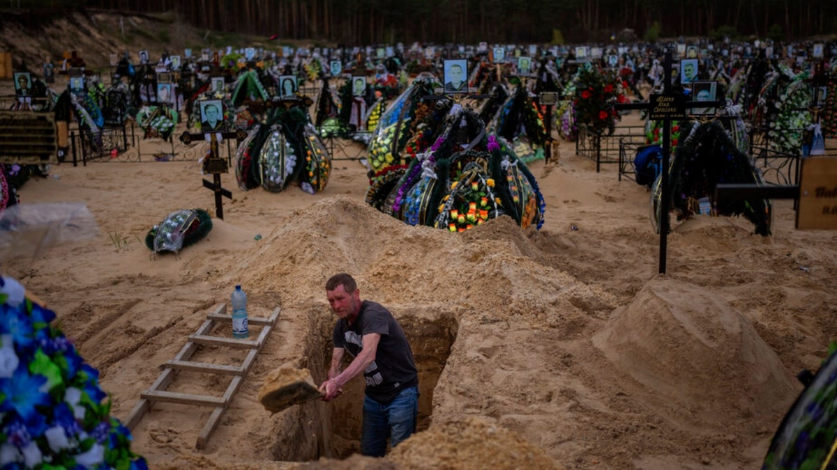 A gravedigger digs a grave at Irpin's cemetery