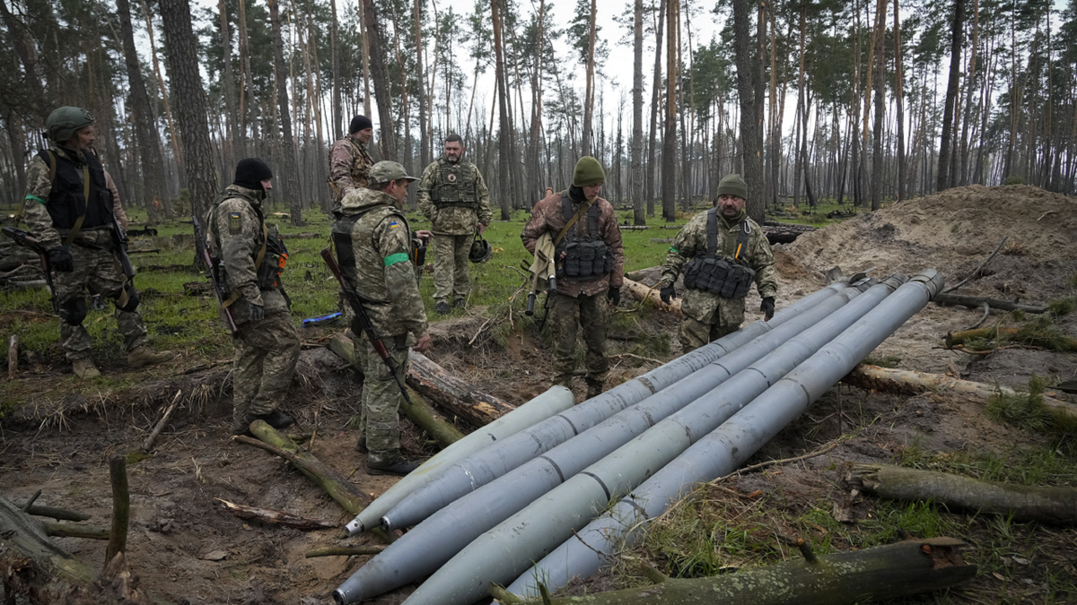 Ukrainian soldiers examine Russian multiple missiles abandoned by Russian troops, in the village of Berezivka, Ukraine, on April 21.