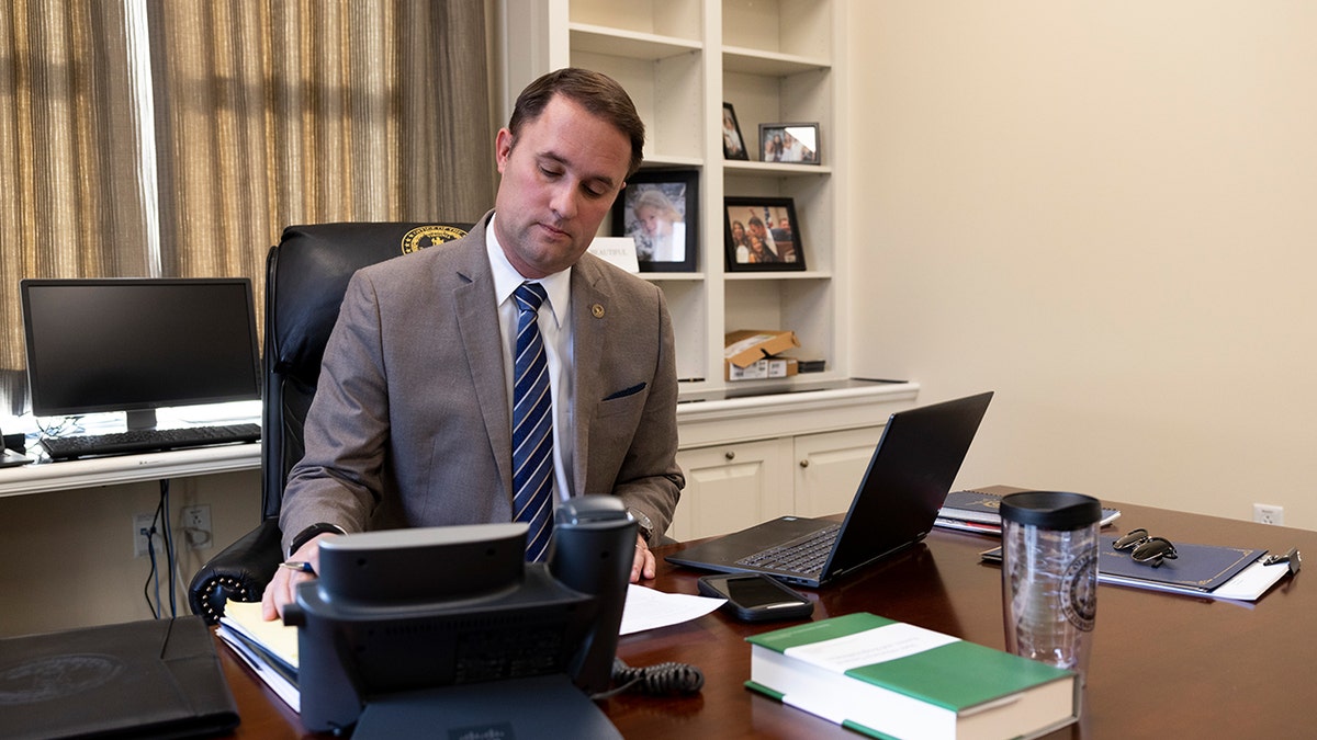 Attorney General of Virginia, Jason Miyares, sitting at a desk