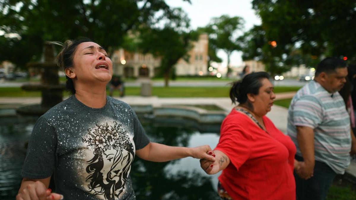 Community holds hands and mourn