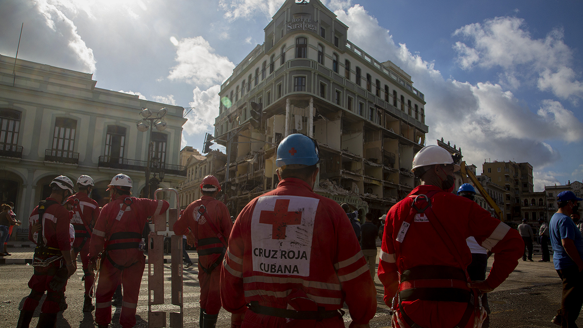 Members of the Red Cross gather near the ruins at the site of a deadly explosion that destroyed the five-star Hotel Saratoga in Old Havana, Cuba, on Sunday, May 8.