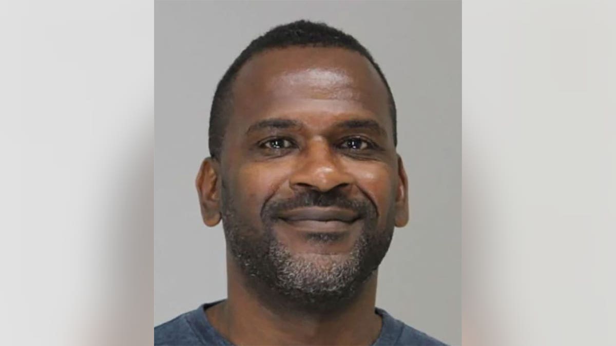 Dallas police Officer Tyrone Williams Jr. smiles in booking photo