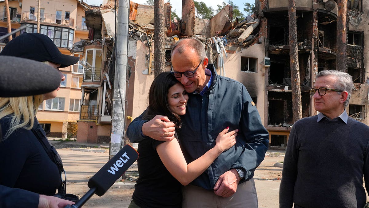 The Chairman of the German Christian Democratic Party (CDU) Friedrich Merz, center right, hugs with Halyna Yanchenko, a member of the Servant of the People political party, in Irpin, Ukraine, Tuesday, May 3, 2022. (AP Photo/Efrem Lukatsky)