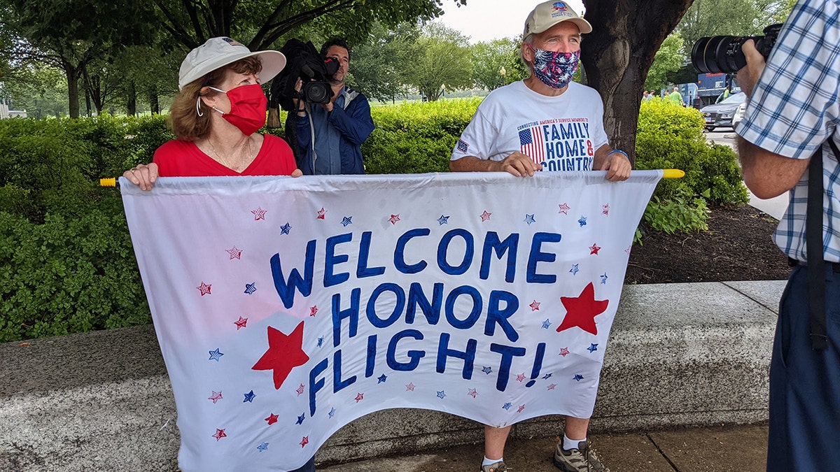 Honor Flight supporters holding a bannerr