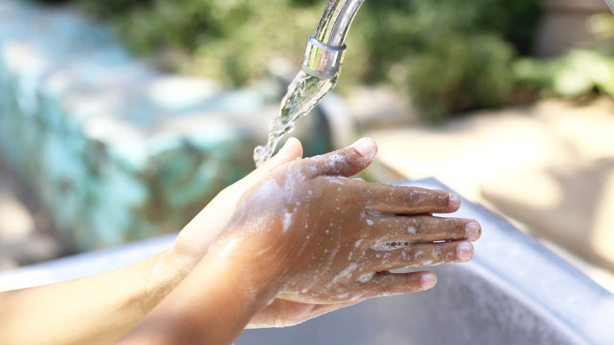 Person washes hands in an outdoor sink