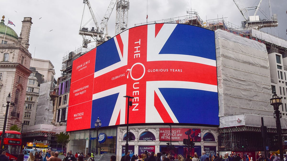 A Union Jack with a celebration of The Queen is displayed on the Piccadilly Lights