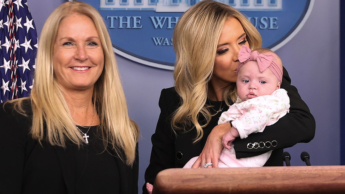 Former White House Press Secretary Kayleigh McEnany holds her five-month-old daughter Blake Gilmartin after posing for photographs with her mother Leanne McEnany (R) at the podium in the Brady Press Briefing Room at the White House May 01, 2020 in Washington, DC.