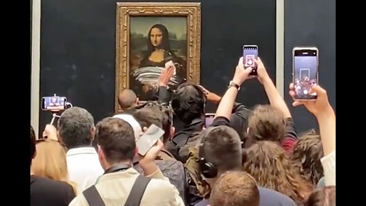 A museum staffer cleans the Mona Lisa's glass following an attack on the painting. 
