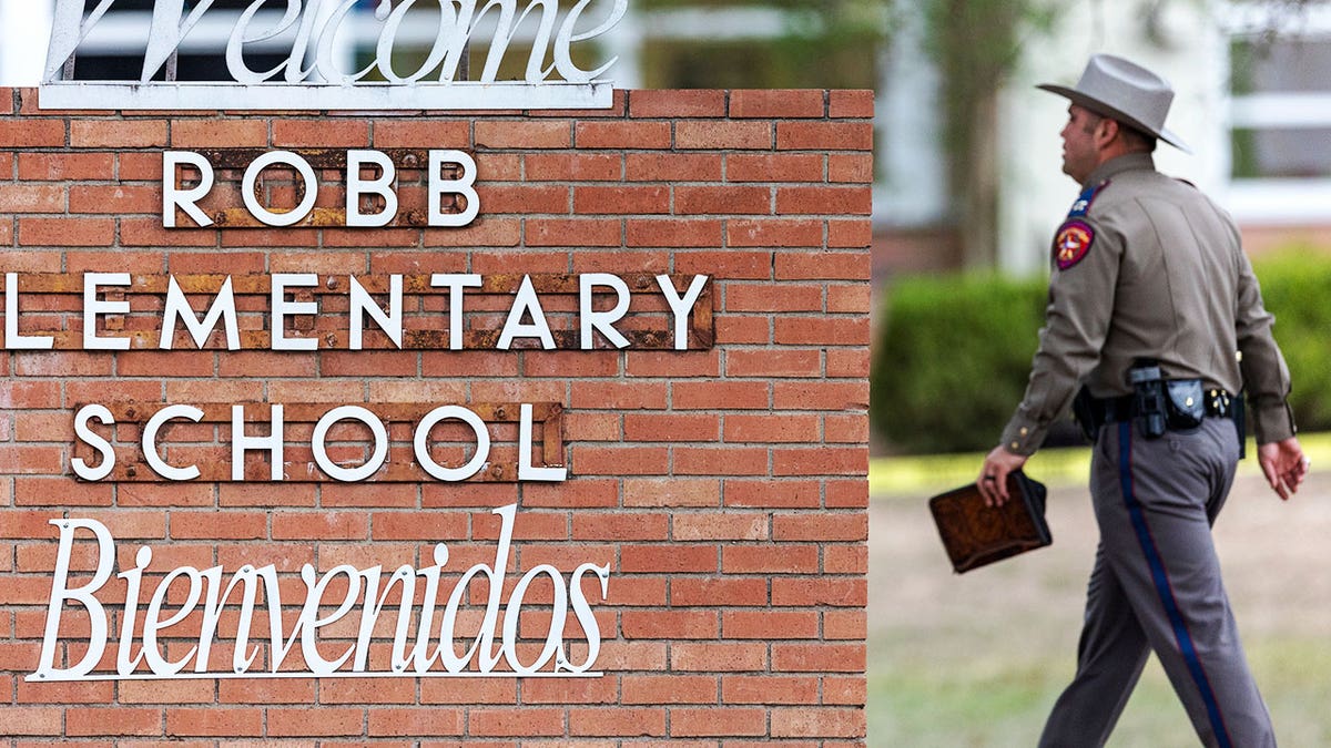 State trooper walks toward Robb Elementary School.