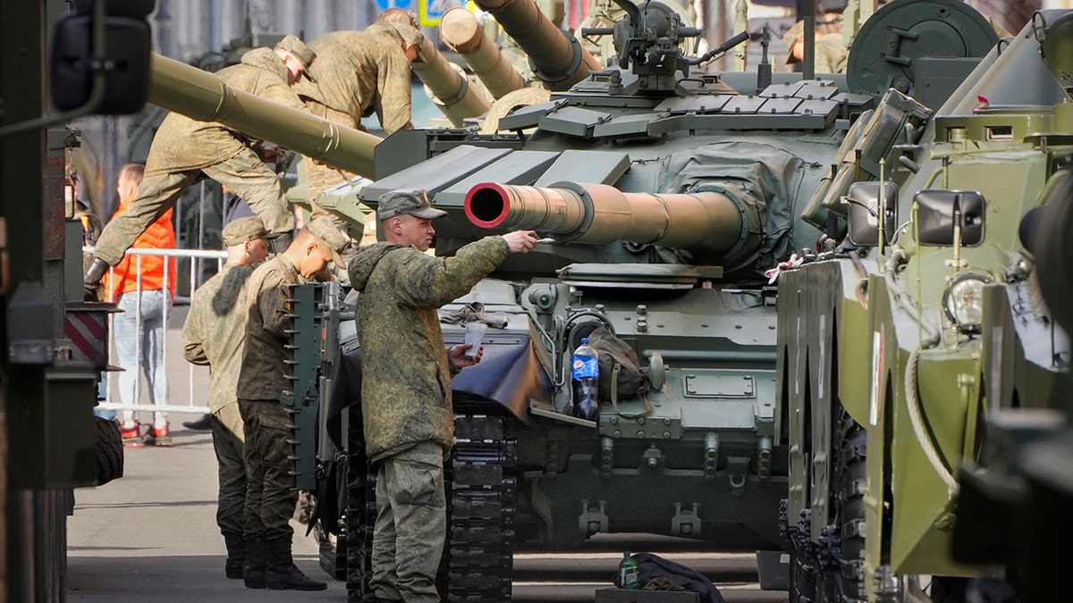 Russian soldiers tint their T-72 tanks on the eve of the Victory Day military parade which will take place at Dvortsovaya (Palace) Square on May 9 to celebrate 77 years after the victory in World War II in St. Petersburg, Russia, Sunday, May 8, 2022.