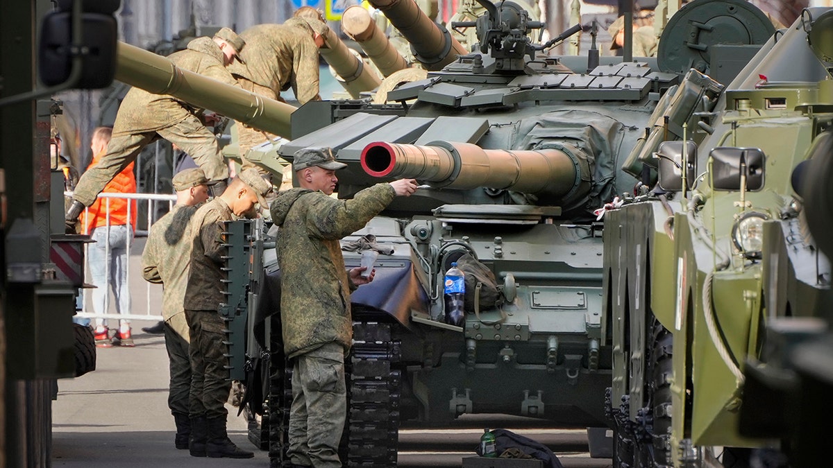 Russian soldiers tending to their tanks in preparation for a military parade