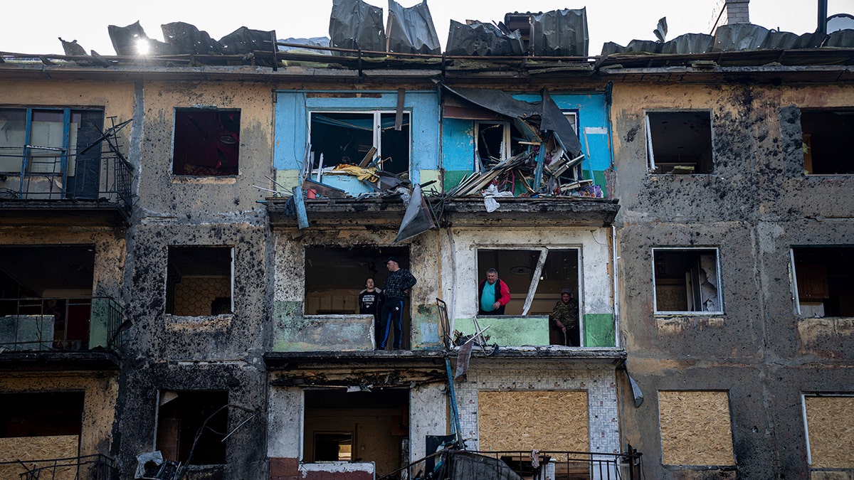 Local residents clean their apartments damaged by Russian shelling in Dobropillya, Donetsk region, eastern Ukraine, Saturday, April 30, 2022.