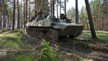 Ukrainian soldiers are seen riding on an armored presonnel carrier during an exercise not far from Kharkiv on April 30.