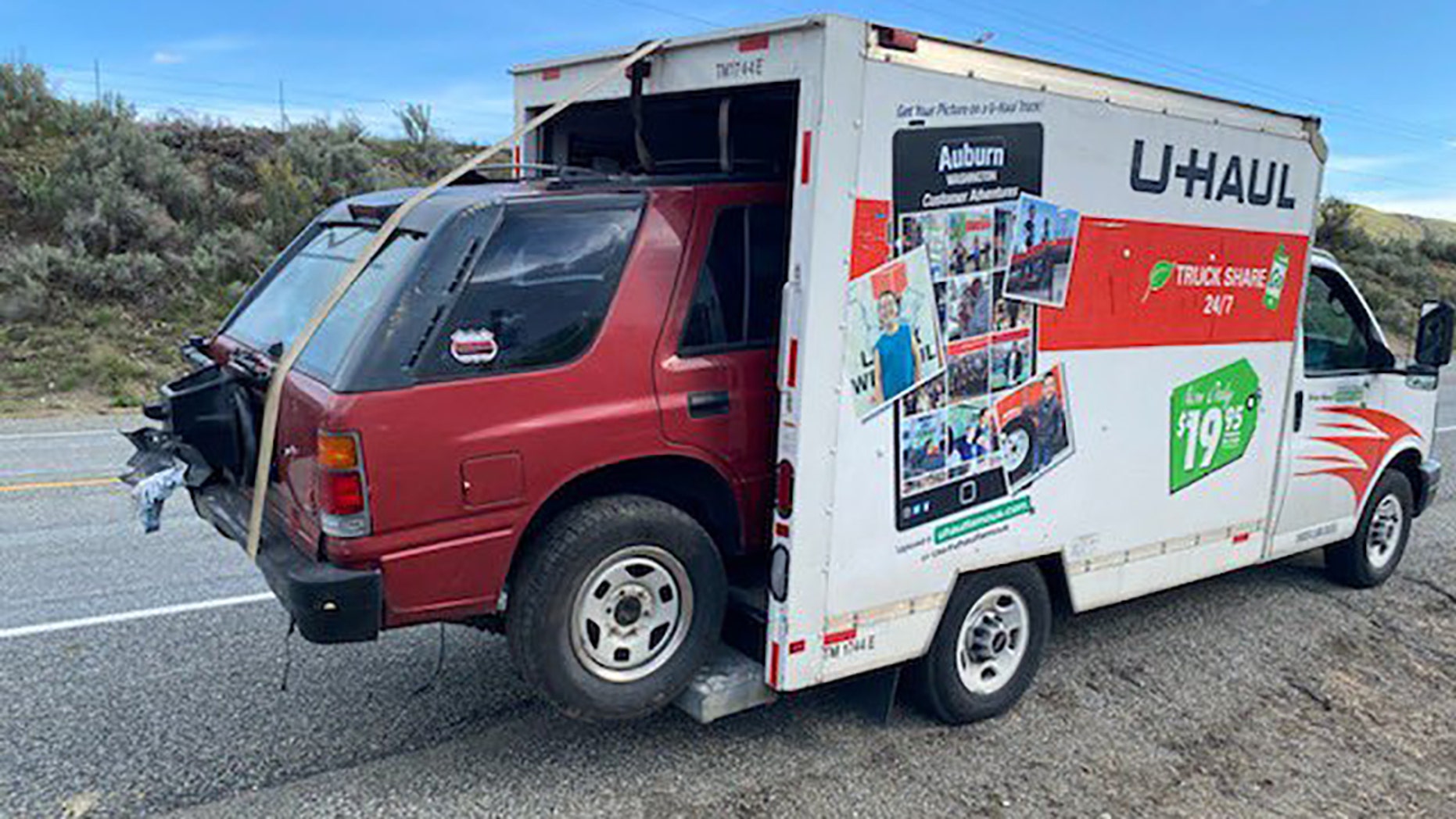 A vehicle sticking out of a U-Haul truck 