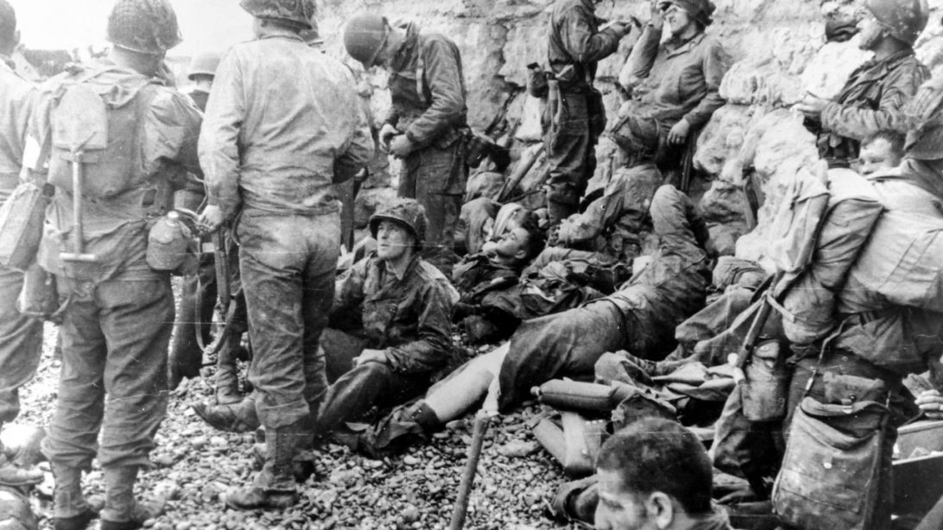American assault troops receive medical aid in Normandy while they rest.