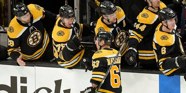 Boston Bruins' Brad Marchand (63) celebrates with teammates after scoring in the third period of Game 4 of an NHL hockey Stanley Cup first-round playoff series against the Carolina Hurricanes, 星期日, 可能 8, 2022, 在波士顿.