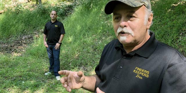 Dennis Parada, right, and his son Kem Parada stand at the site of the FBI's dig for Civil War-era gold in Sept, 2018, in Dents Run, Pennsylvania.