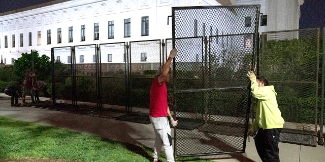 Workers assemble non-scalable fences around the Supreme Court amid ongoing abortion-rights demonstrations on May 4, 2022, in Washington.