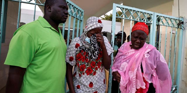 Senegalese families receive grave news from the Diali Kaba sits and cries outside Mame Abdou Aziz Sy Dabakh hospital in Tivaouane, Senegal, where a fire broke out in a neonatal ward on Wednesday, May 25, 2022. Eleven babies perished in the blaze, including Diali Kaba's (middle) newborn.