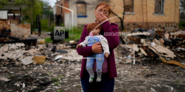 Nila Zelinska holds a doll belonging to her granddaughter, she was able to find in her destroyed house in Potashnya outskirts Kyiv, Ukraine, Tuesday, May 31.