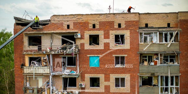 Rescuers inspect an apartment building damaged in a nighttime missile attack in Sloviansk, Ukraine, Tuesday, May 31.