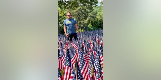 Tom Satterly with a sea of American flags. "Our souls and our hearts, as well as our bodies, have blisters on them," he wrote in his book. "We're wounded and exhausted … But just keep moving forward, always forward."