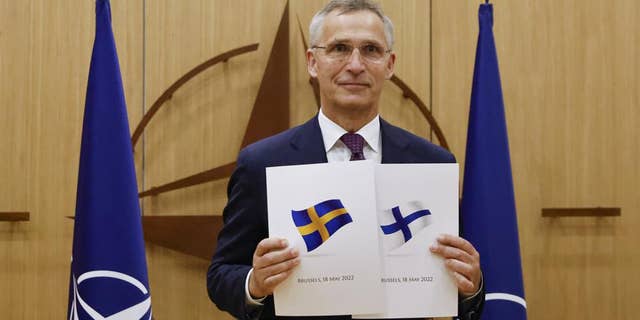 NATO Secretary-General Jens Stoltenberg displays documents as Sweden and Finland applied for membership in Brussels, Belgium, May 18.