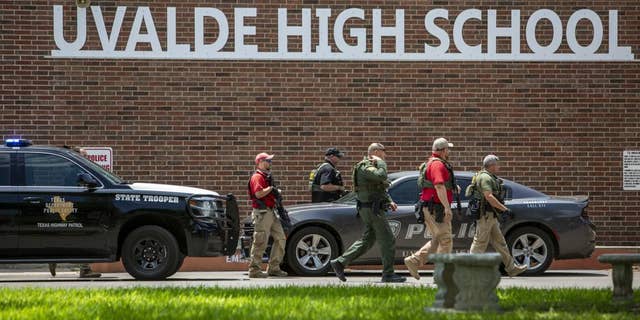 Law enforcement personnel walk outside Uvalde High School after shooting a was reported earlier in the day at Robb Elementary School, 星期二, 可能 24, 2022, (乌瓦尔德), 德州.