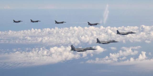 In this photo provided by the Joint Staff of the Japanese Self-Defense Force, three F-15 warplanes of the Japanese Self-Defense Force, front, and four F-16 fighters of the U.S. Armed Forces fly over the Sea of Japan Wednesday, May 25, 2022.