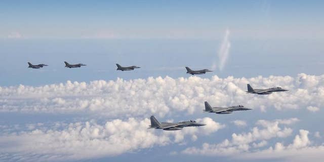 In this photo provided by the Joint Staff of the Japanese Self-Defense Force, three F-15 warplanes of the Japanese Self-Defense Force, front, and four F-16 fighters of the U.S. Armed Forces fly over the Sea of Japan Wednesday, May 25, 2022.