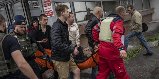 An injured man as a result of shelling is carried on a stretcher in Kharkiv, eastern Ukraine, on Thursday, May 26.