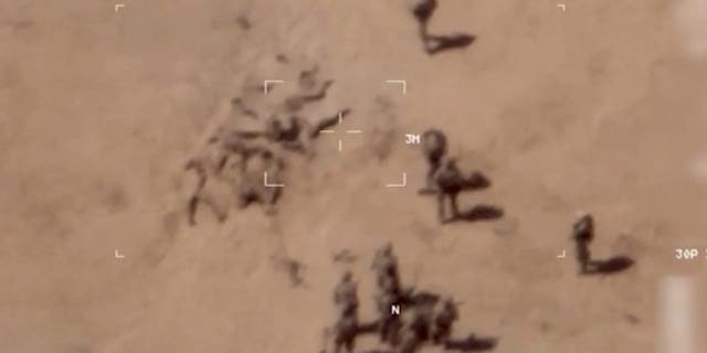 This image taken from a video shows soldiers burying bodies near an army base in northern Mali. The French military says it has videos of Russian mercenaries burying bodies near an army base in northern Mali.