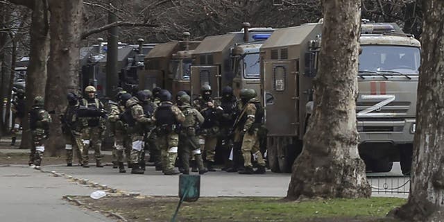 Russian army soldiers stand next to their trucks during a rally against Russian occupation in Svobody (Freedom) Square in Kherson, Ukraine, Monday, March 7, 2022. Ever since Russian forces took the southern Ukrainian city of Kherson in early March, residents sensed the occupiers had a special plan for their town. 