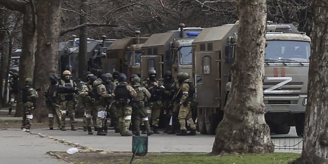 Russian army soldiers stand next to their trucks during a rally against Russian occupation in Svobody (Freedom) Square in Kherson, Ukraine, Monday, March 7, 2022. Ever since Russian forces took the southern Ukrainian city of Kherson in early March, residents sensed the occupiers had a special plan for their town. 