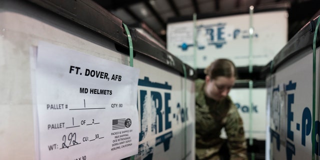 U.S. Air Force Airman Megan Konsmo, of Tacoma, Wash., checks pallets of helmets bound for Ukraine in the 436th Airport Squadron Super Port, Friday, April 29, 2022, at the Air Force Base in Dover, Del.