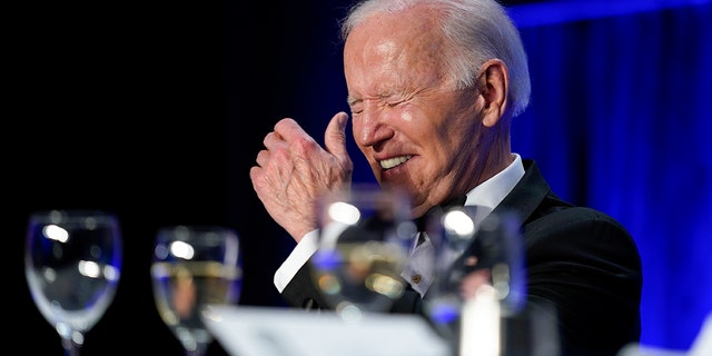 President Joe Biden laughs as he listens to Trevor Noah, host of Comedy Central's 
