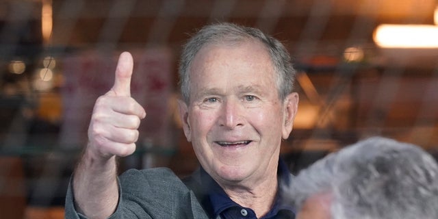 Former President George W. Bush gives a thumbs-up before a baseball game between the Atlanta Braves and the Texas Rangers in Arlington, Texas. Bush will appear at a fundraiser for Gov. Brian Kemp, according to reports. 