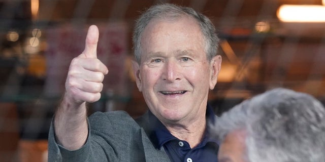 Former President George W. Bush gives a thumbs-up before a baseball game between the Atlanta Braves and the Texas Rangers in Arlington, Texas. Bush will appear at a fundraiser for Gov. Brian Kemp, according to reports.