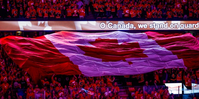 Calgary Flames fans sing the Canadian national anthem before Game 1 of the team's NHL hockey first-round playoff series against the Dallas Stars on Tuesday, May 3, 2022, in Calgary, Alberta. 