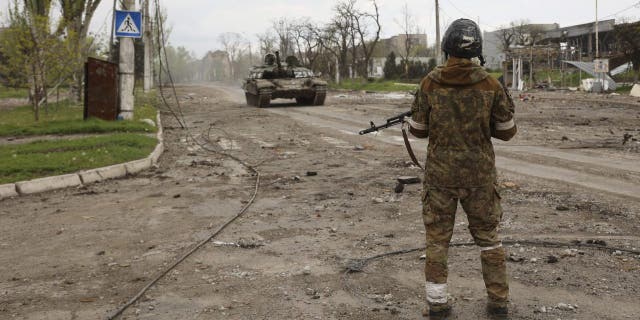 A serviceman of Donetsk People's Republic militia stands at a check point in Mariupol, in territory under the government of the Donetsk People's Republic, eastern Ukraine, Wednesday, May 4, 2022. 