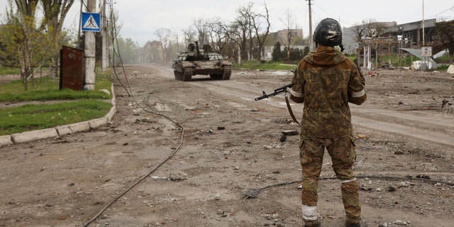 A serviceman of Donetsk People's Republic militia stands at a checkpoint in Mariupol, eastern Ukraine, Wednesday, May 4, 2022.