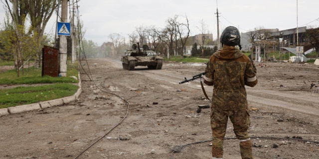 A serviceman of Donetsk People's Republic militia stands at a checkpoint in Mariupol, eastern Ukraine, Wednesday, May 4, 2022.