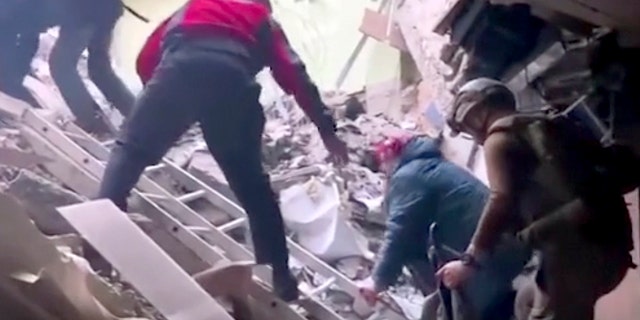 FILE - This frame taken from an undated video provided Sunday, May 1, 2022, by the Azov Special Forces Regiment of the Ukrainian National Guard shows people climbing over debris at the Azovstal steel plant, in Mariupol, eastern Ukraine. 