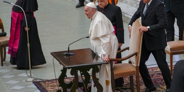 Pope Francis attends an audience with nuns and religious superiors after arriving in a wheelchair in the Paul VI Hall at The Vatican, Thursday, May 5, 2022. Francis, 85, has been suffering from strained ligaments in his right knee for several months. He revealed he recently received some injections to try to relieve the pain, but he has continued to struggle to walk and stand. (AP Photo/Alessandra Tarantino)