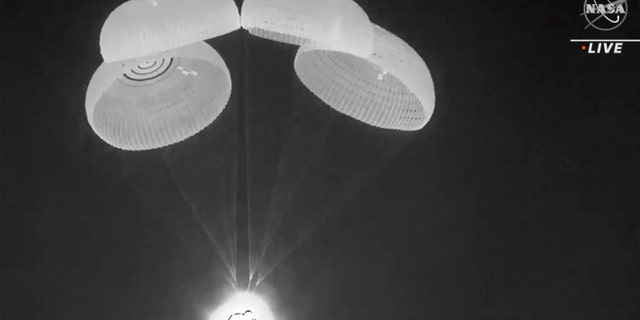 In this image made from video supplied by NASA, SpaceX Dragon capsule uses parachutes as it descends in the Gulf of Mexico early Friday, May 6, 2022. NASA’s Raja Chari, Tom Marshburn and Kayla Barron, and the European Space Agency’s Matthias Maurer undocked from the International Space Station less than 24 hours earlier. (NASA via AP)