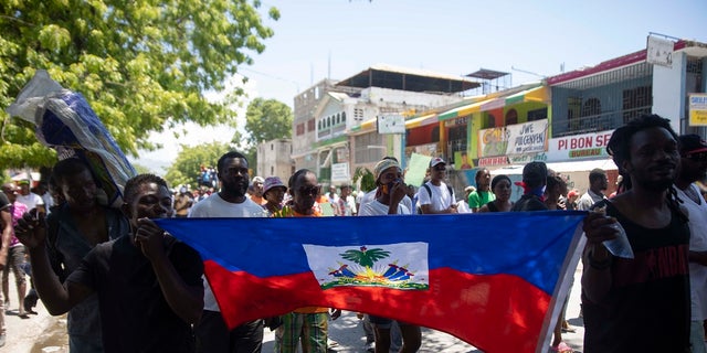 Demonstrators march demanding peace and security in La Plaine neighborhood of Port-au-Prince, Haiti on May 6. The leader of a Haitian gang has been charged in the kidnapping of US missionaries.